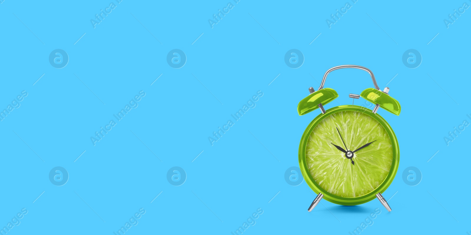 Image of Juicy lime on alarm clock dial against light blue background. Creative poster with space for text, banner design