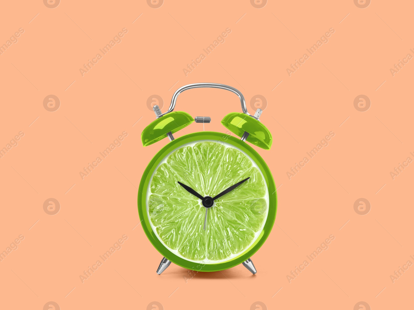 Image of Juicy lime on alarm clock dial against pink background. Creative poster