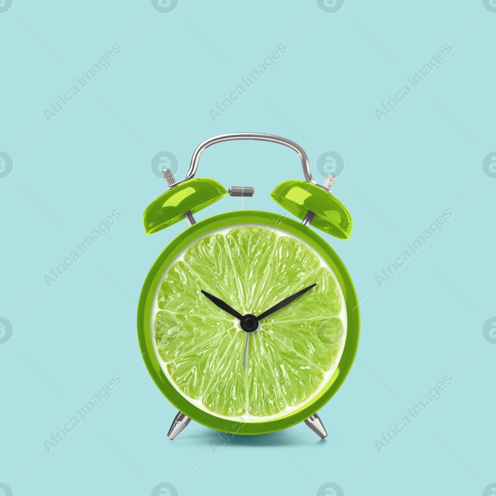 Image of Juicy lime on alarm clock dial against light blue background. Creative poster