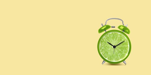 Image of Juicy lime on alarm clock dial against light orange background. Creative poster with space for text, banner design