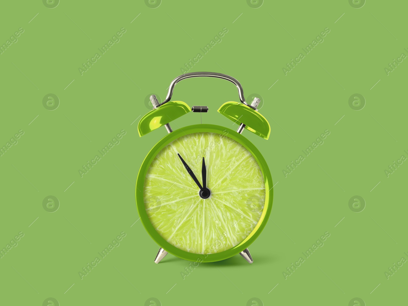 Image of Juicy lime on alarm clock dial against light green background. Creative poster