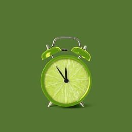 Image of Juicy lime on alarm clock dial against green background. Creative poster