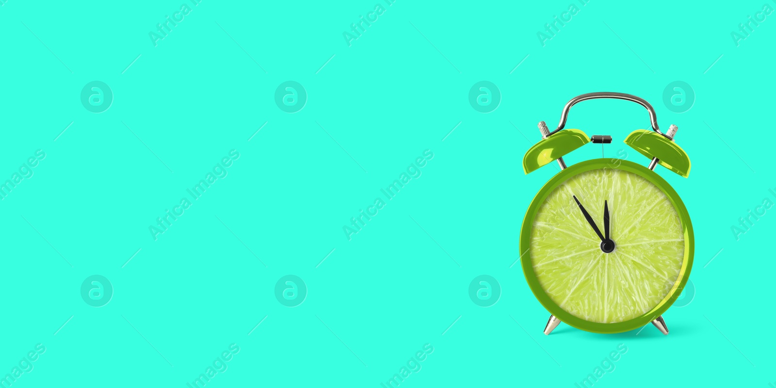 Image of Juicy lime on alarm clock dial against turquoise background. Creative poster with space for text, banner design