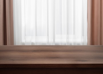 Image of Empty wooden table near window with curtains. Space for design