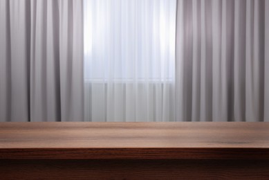 Image of Empty wooden table near window with curtains. Space for design