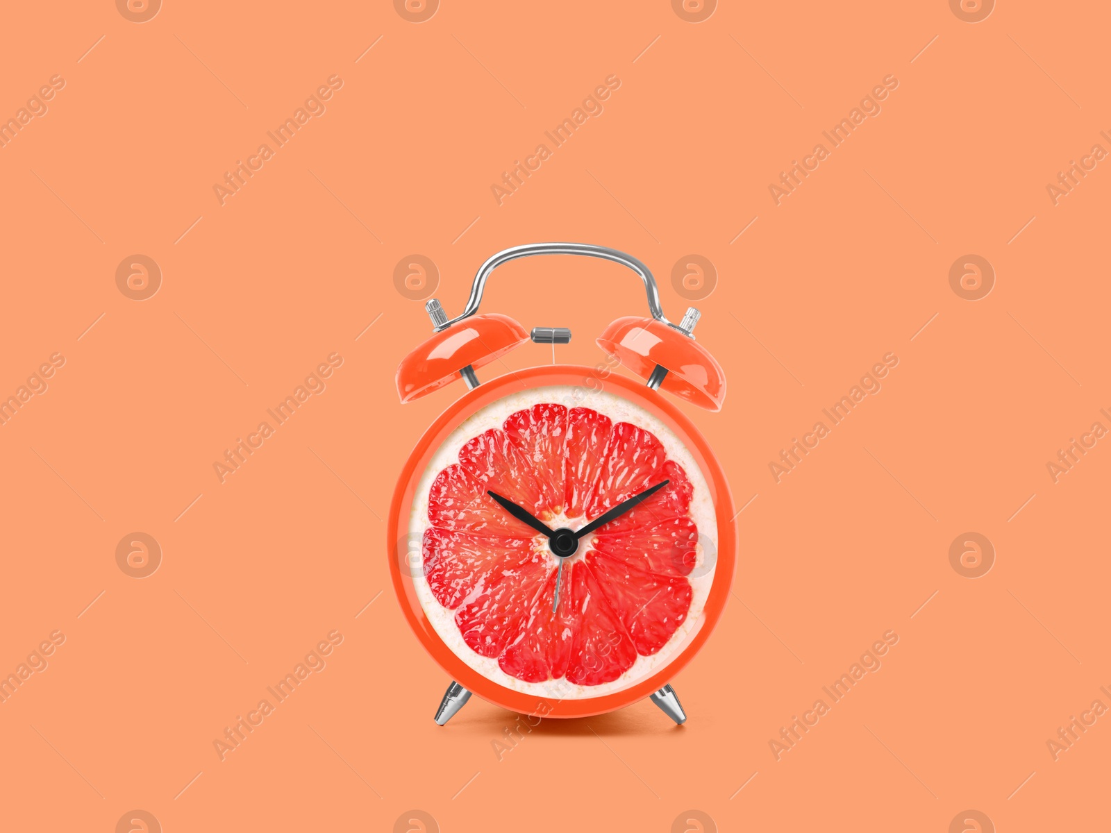 Image of Juicy grapefruit on alarm clock dial against coral background. Creative poster