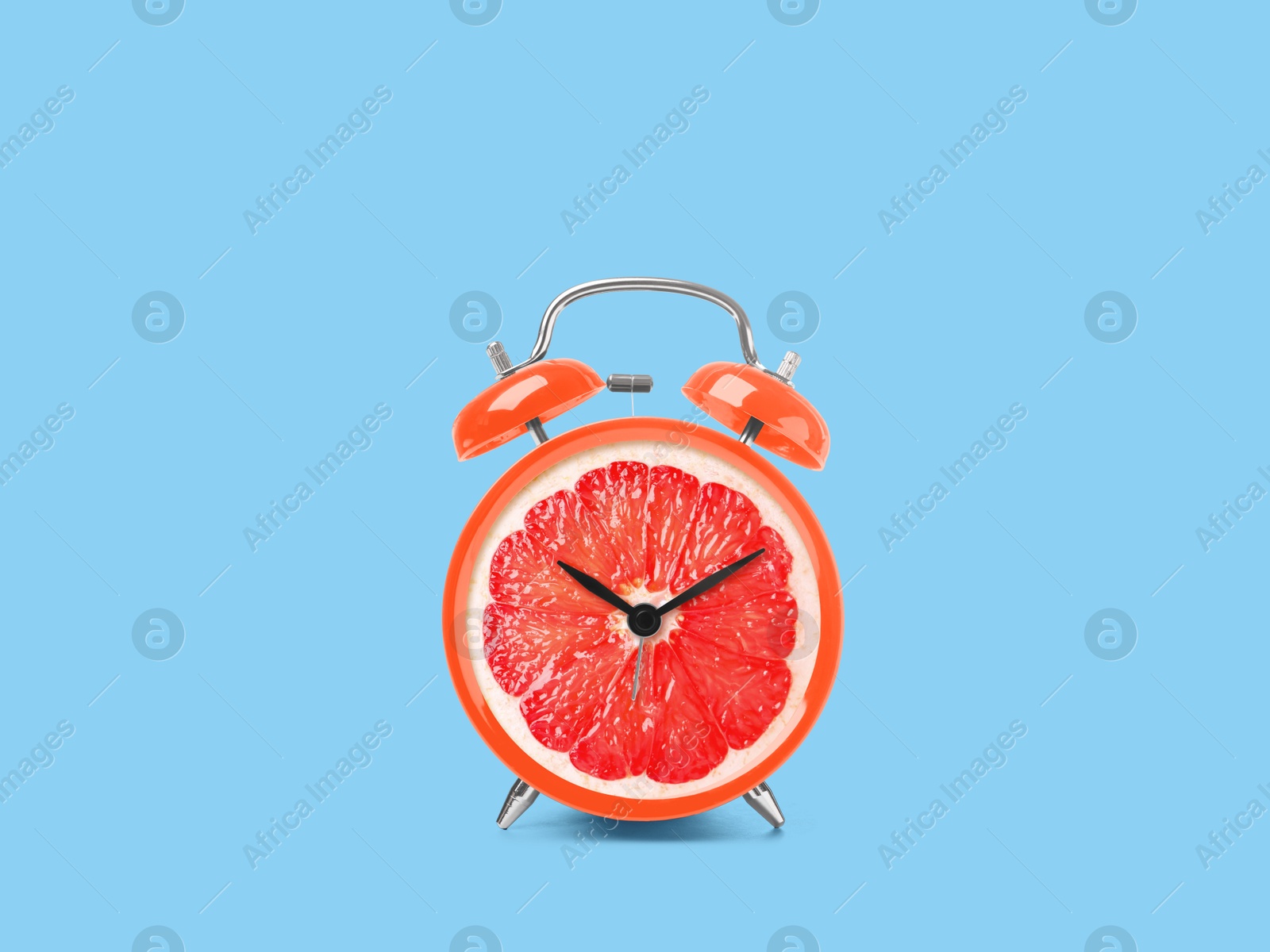 Image of Juicy grapefruit on alarm clock dial against light blue background. Creative poster