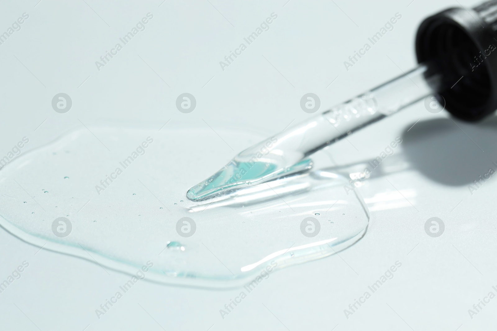 Photo of Pipette with cosmetic serum on light background, closeup