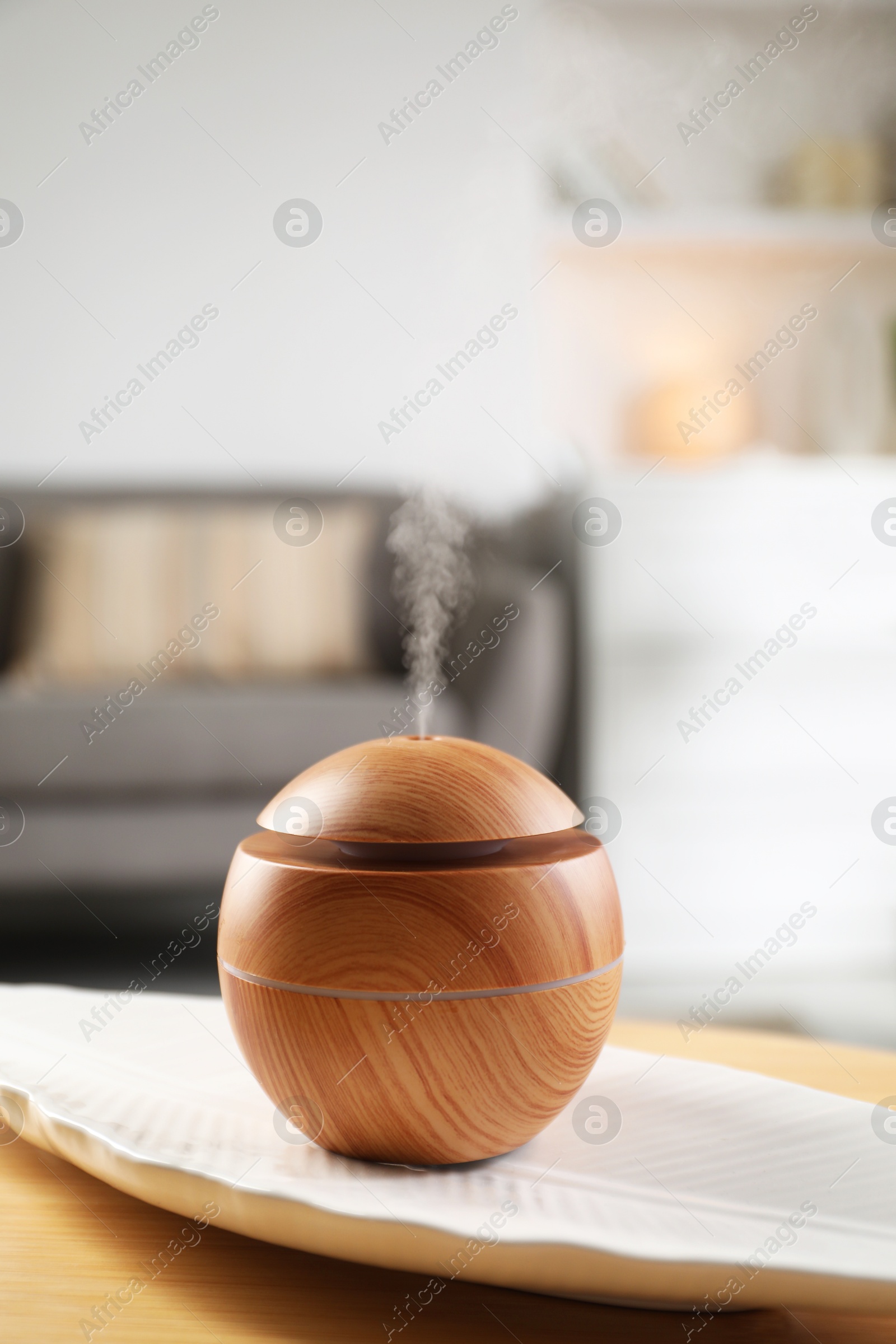 Photo of Essential oil diffuser on wooden table at home