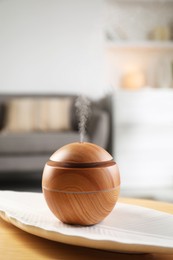 Photo of Essential oil diffuser on wooden table at home