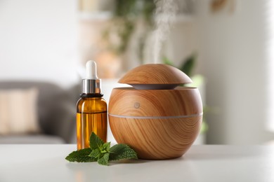 Photo of Essential oil diffuser, cosmetic product and mint on white table at home