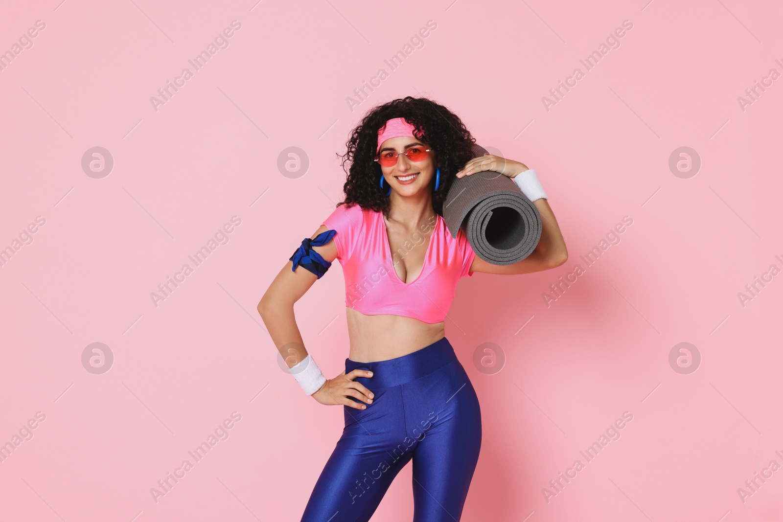 Photo of Aerobics. Happy woman with fitness mat on pink background