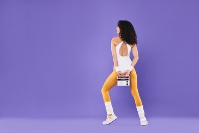 Photo of Aerobics. Woman with radio receiver on purple background