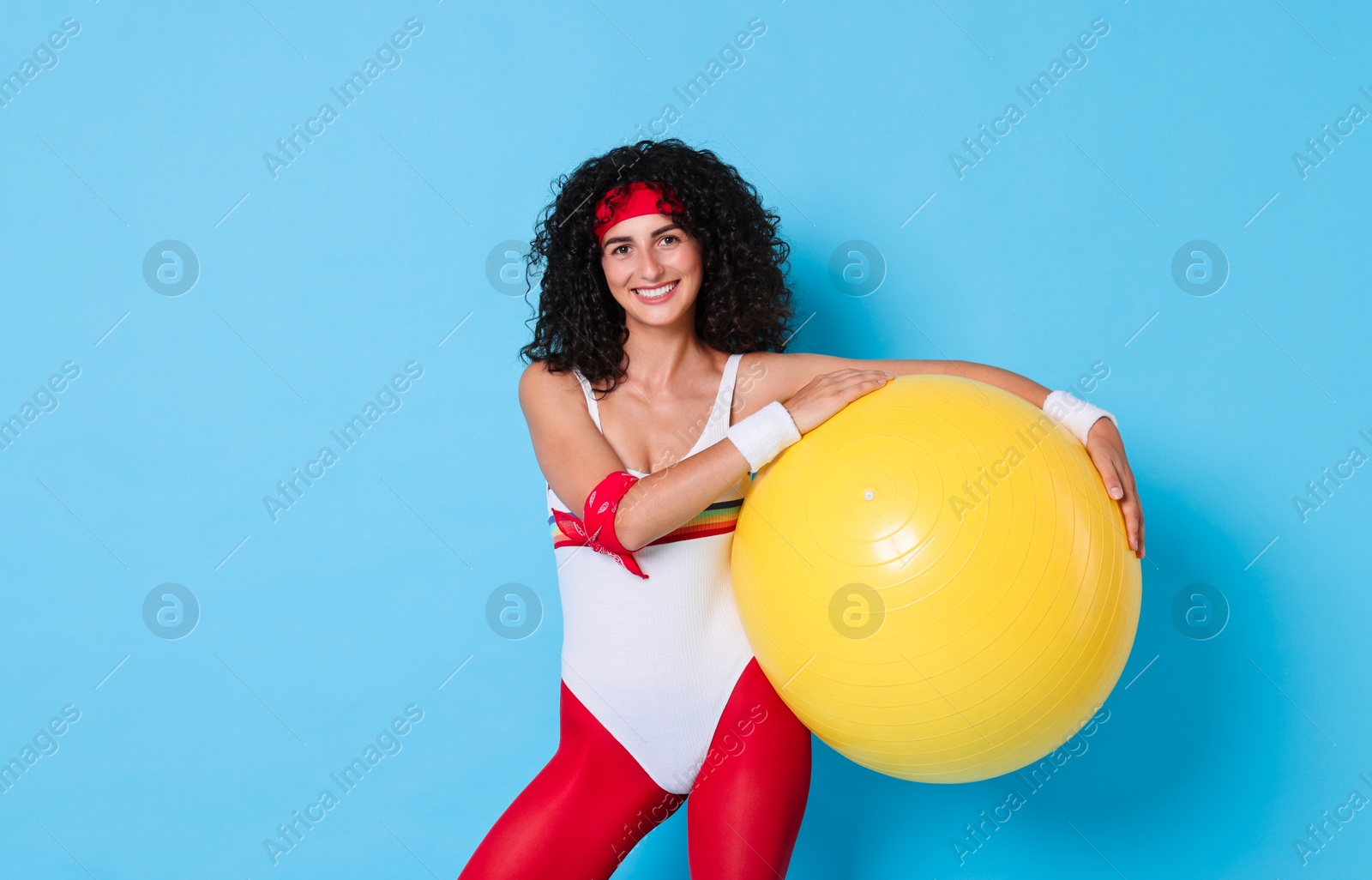 Photo of Aerobics. Happy woman with fitness ball on light blue background