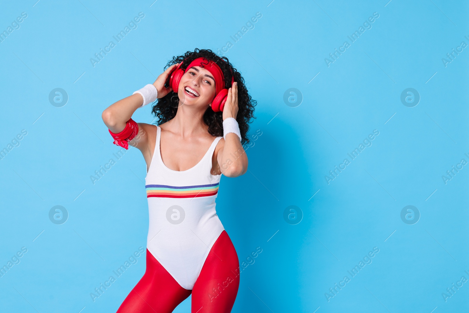 Photo of Aerobics. Happy woman in headphones on light blue background, space for text