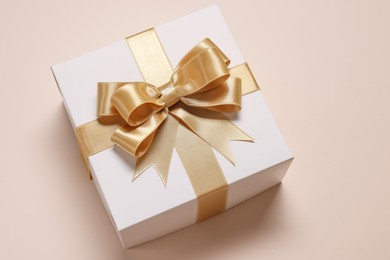 Gift box with bow on beige background