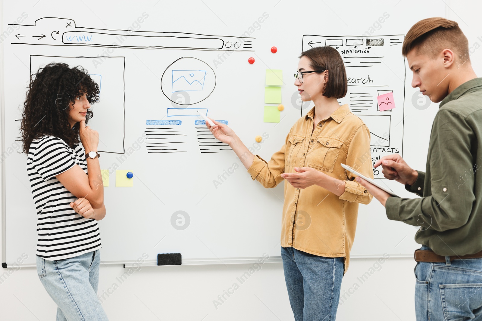 Photo of Developing UI design. People drawing website wireframe on whiteboard indoors