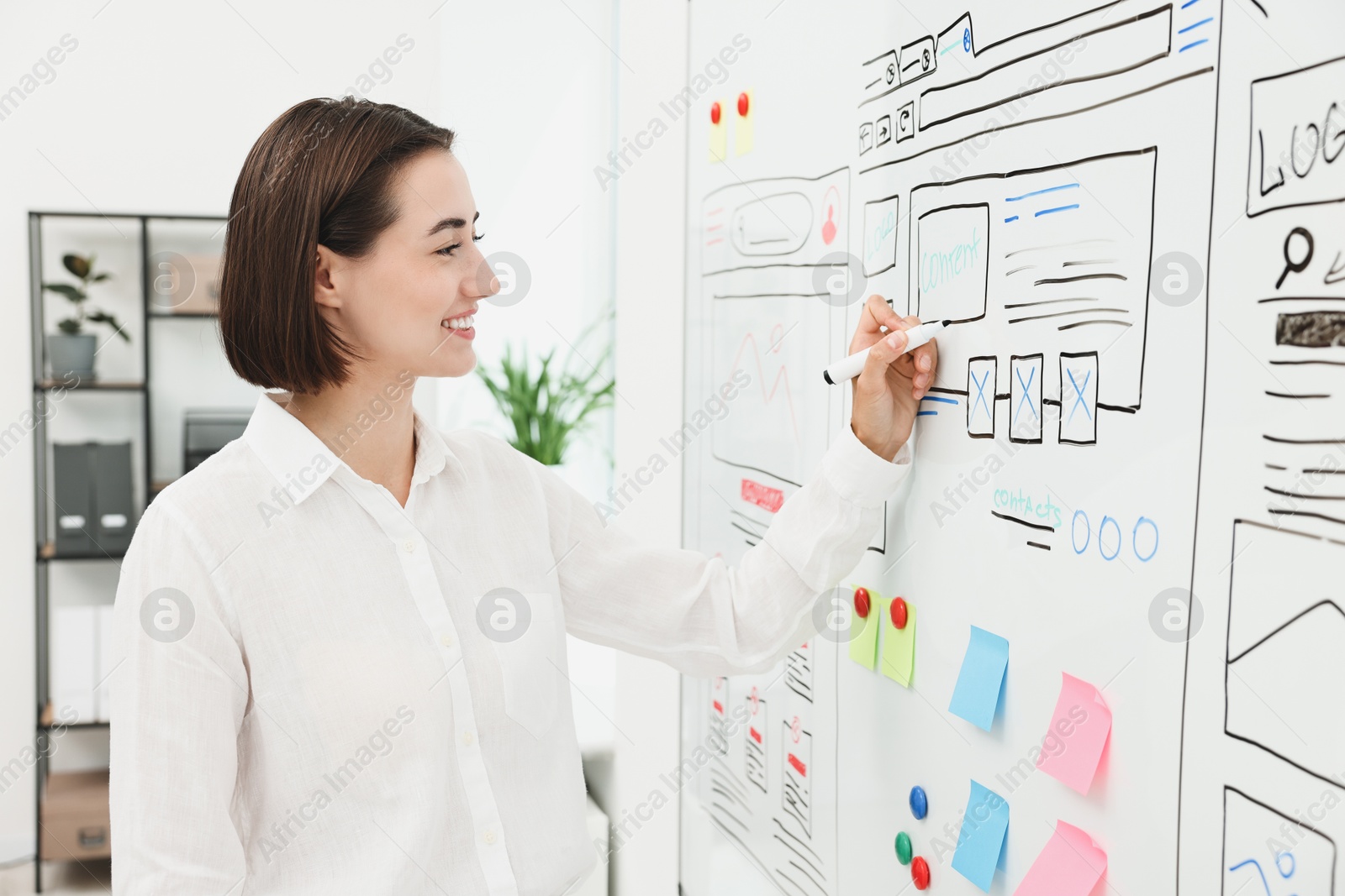 Photo of Developing UI design. Woman drawing website wireframe on whiteboard indoors