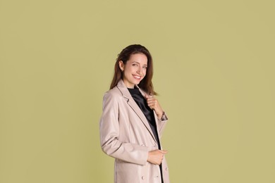 Photo of Beautiful woman in stylish beige jacket on olive background