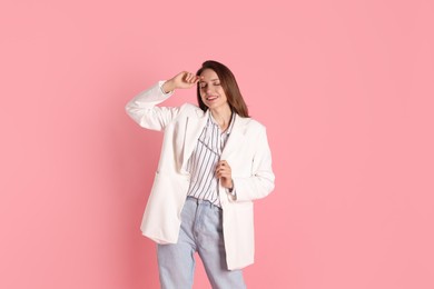 Beautiful woman in stylish white jacket on pink background