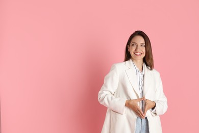 Beautiful woman in stylish white jacket on pink background, space for text