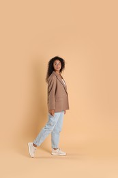 Photo of Beautiful woman in stylish jacket on beige background