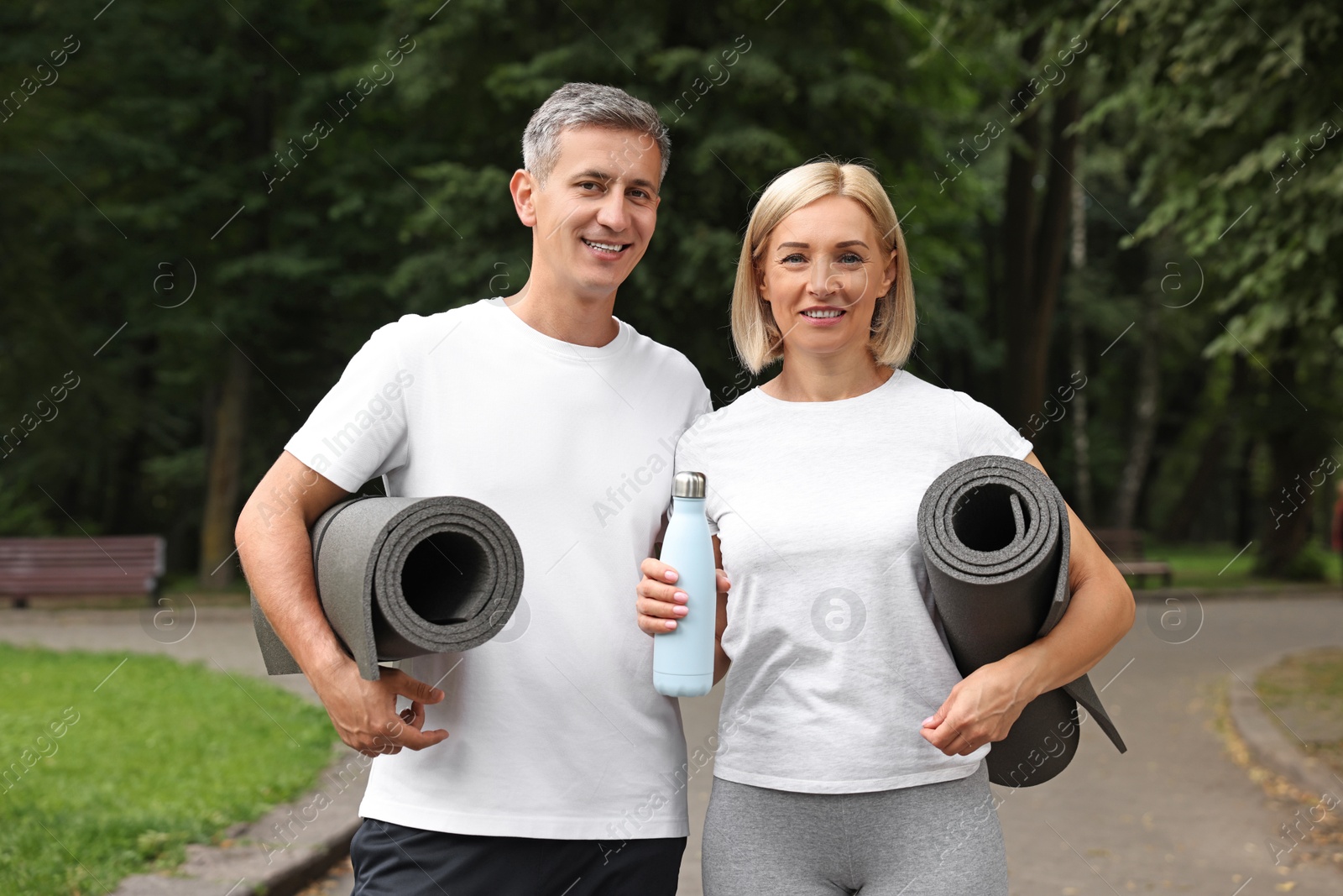 Photo of Happy couple with yoga mats in park