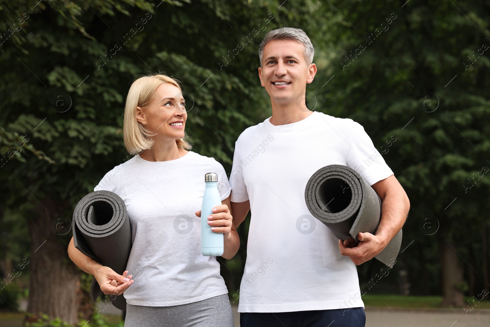 Photo of Happy couple with yoga mats in park