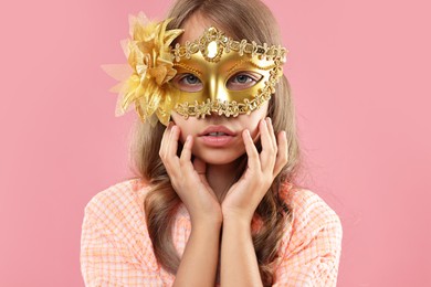 Photo of Cute girl wearing carnival mask on pink background