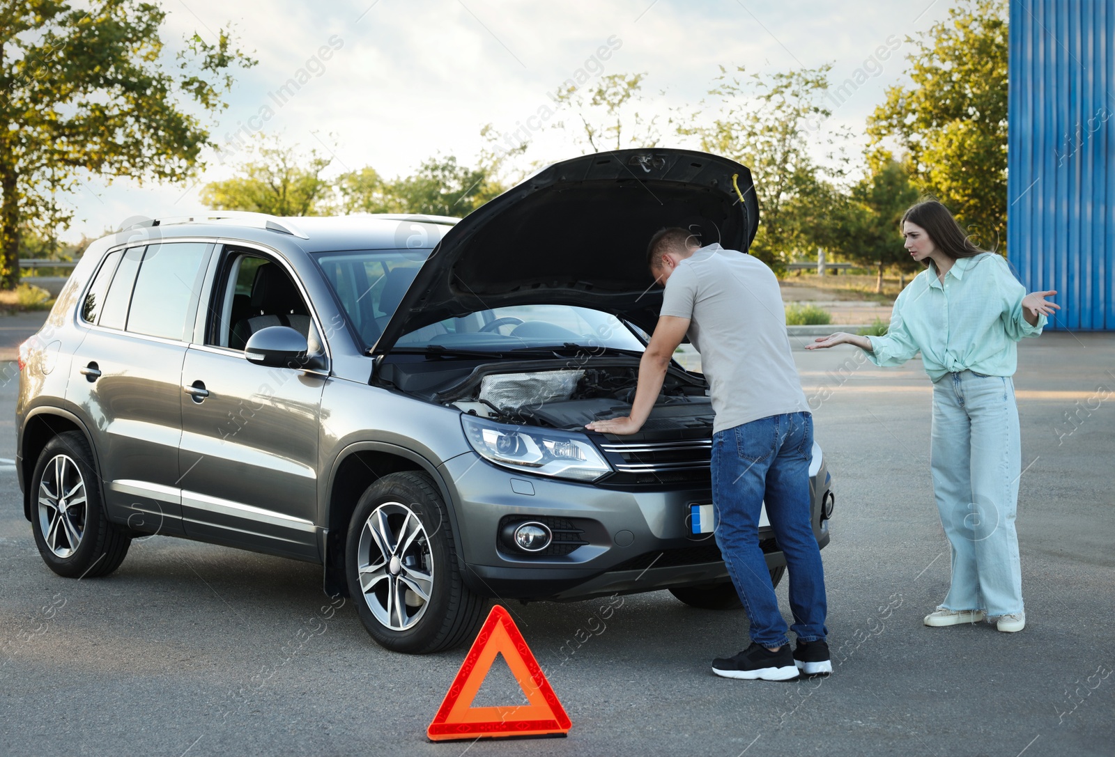 Photo of Man and woman near broken car outdoors