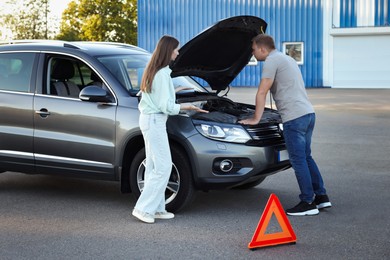 Man and woman near broken car outdoors