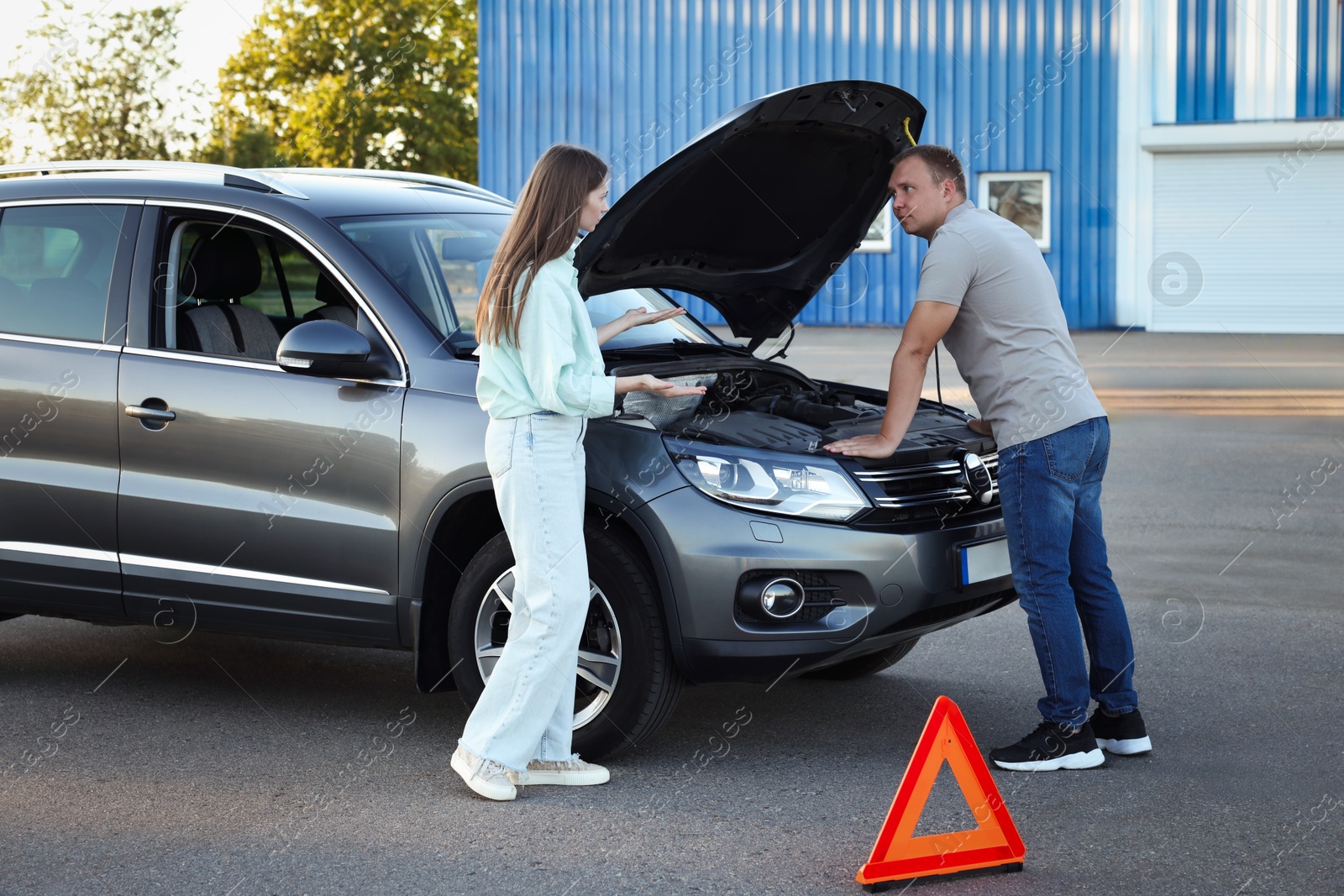 Photo of Man and woman near broken car outdoors