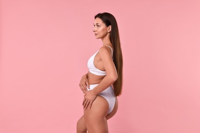 Beautiful woman with perfect skin on pink background. Body care