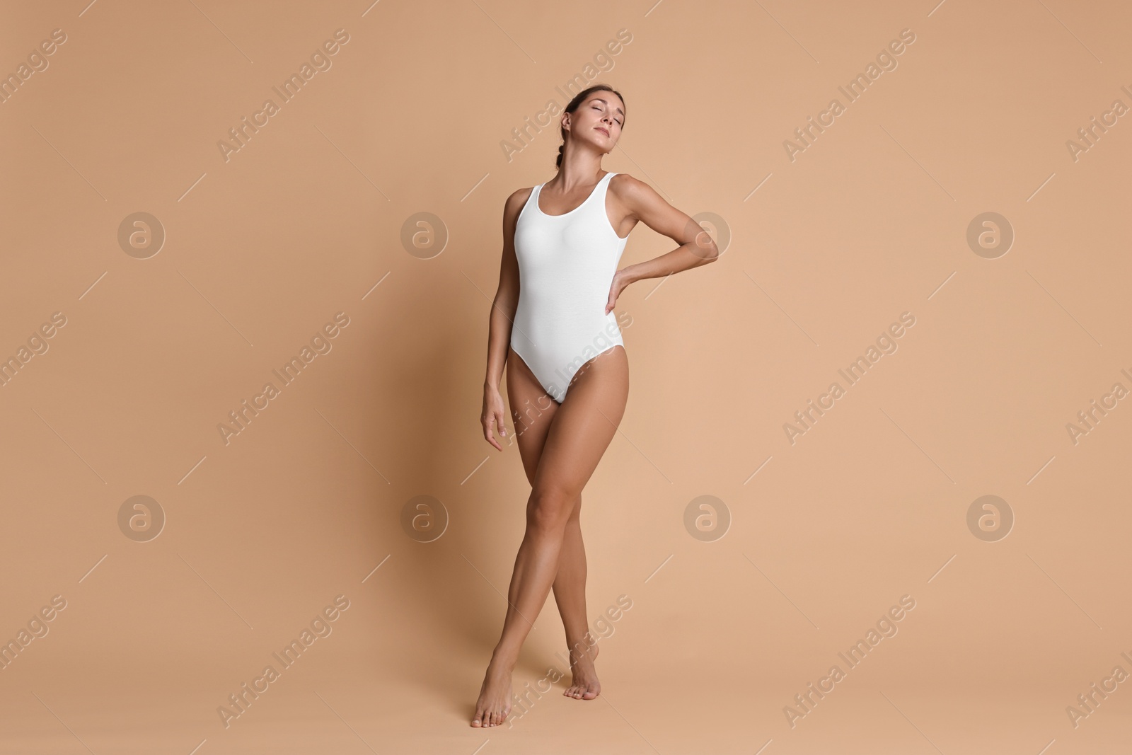 Photo of Beautiful woman with perfect skin posing on beige background. Body care