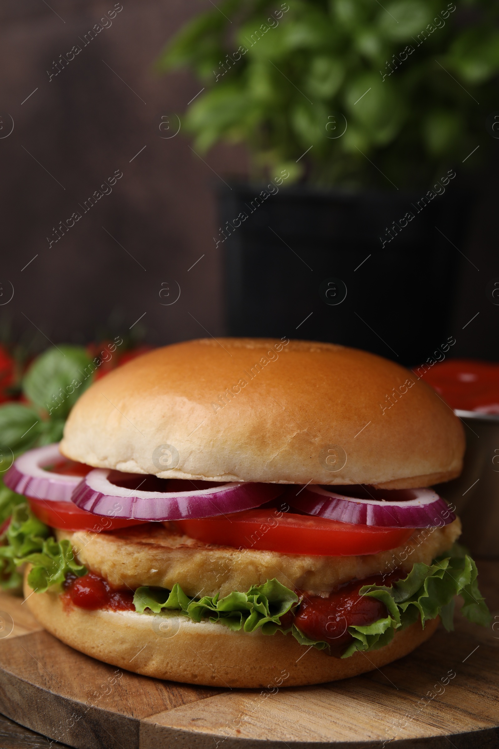 Photo of Delicious vegan burger with chickpea cutlet on wooden table, closeup