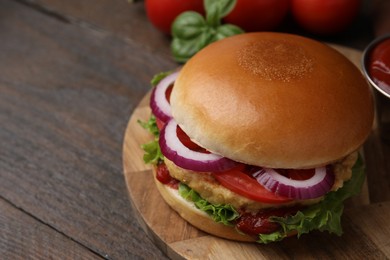 Photo of Delicious vegan burger with chickpea cutlet on wooden table, closeup