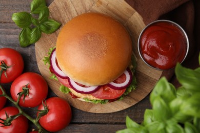 Delicious vegan burger with chickpea cutlet on wooden table, flat lay