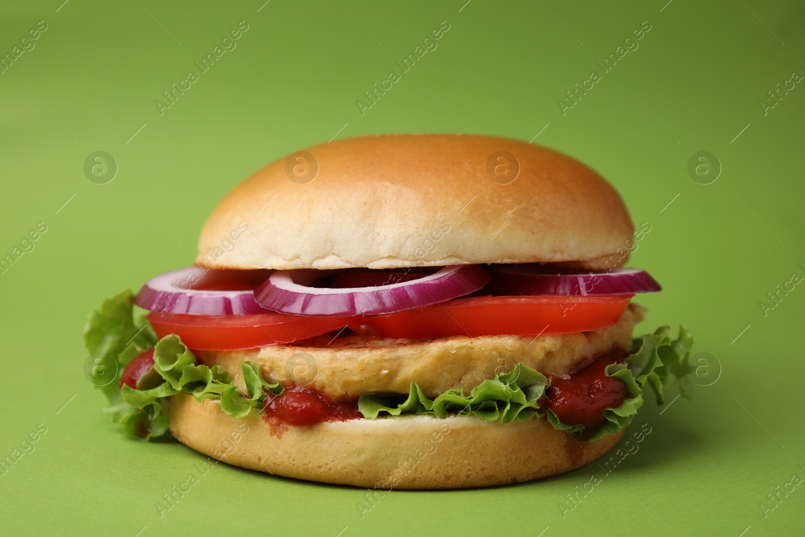 Photo of Delicious vegan burger with chickpea cutlet on green background