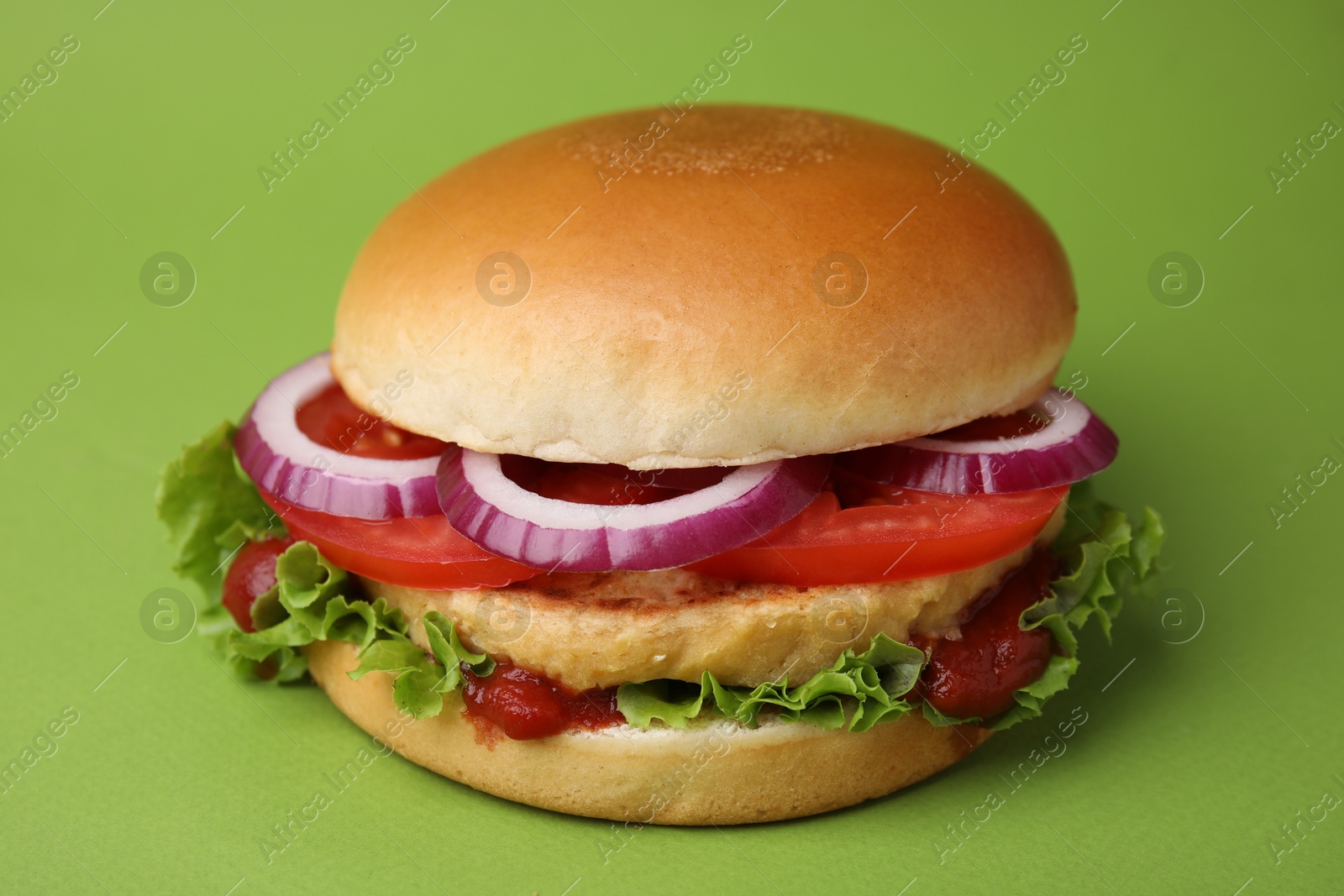 Photo of Delicious vegan burger with chickpea cutlet on green background