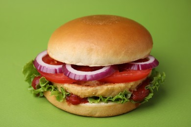 Photo of Delicious vegan burger with chickpea cutlet on green background