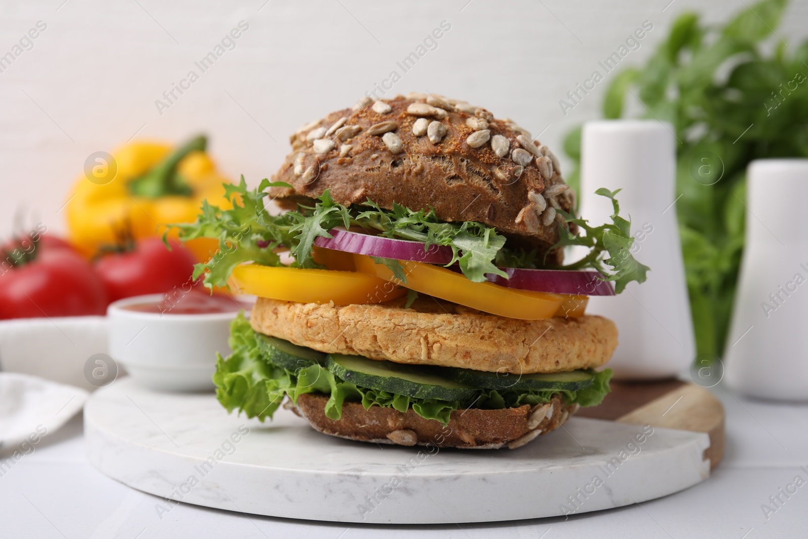 Photo of Delicious vegan burger with chickpea cutlet on white table, closeup