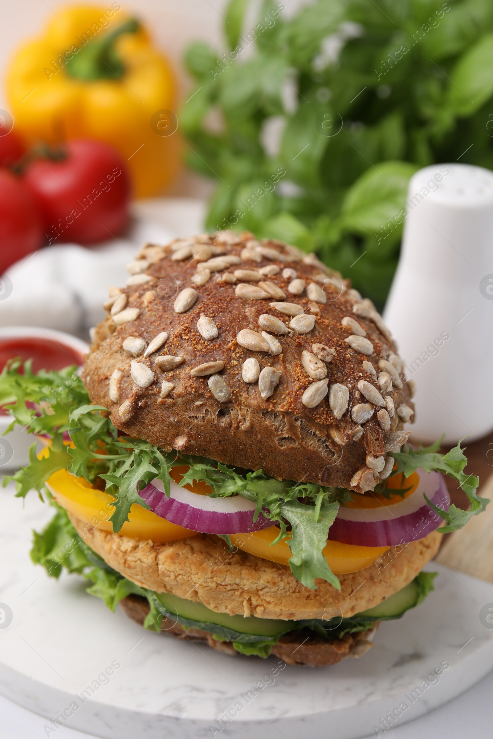 Photo of Delicious vegan burger with chickpea cutlet on white table, closeup