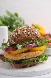 Photo of Delicious vegan burger with chickpea cutlet on white table, closeup