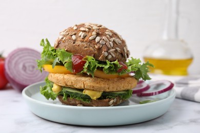 Delicious vegan burger with chickpea cutlet on white marble table, closeup