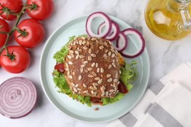 Photo of Delicious vegan burger with chickpea cutlet on white marble table, flat lay