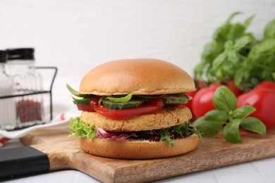 Delicious vegan burger with chickpea cutlet on white tiled table