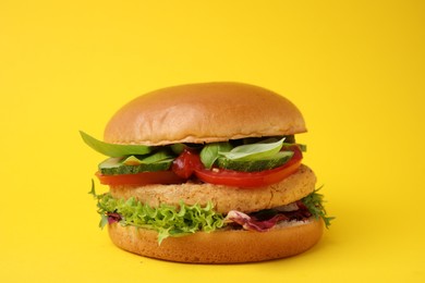 Photo of Delicious vegan burger with chickpea cutlet on yellow background, closeup