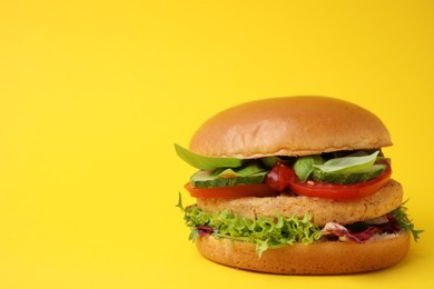 Delicious vegan burger with chickpea cutlet on yellow background. Space for text