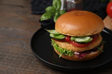 Photo of Delicious vegan burger with chickpea cutlet on wooden table, closeup