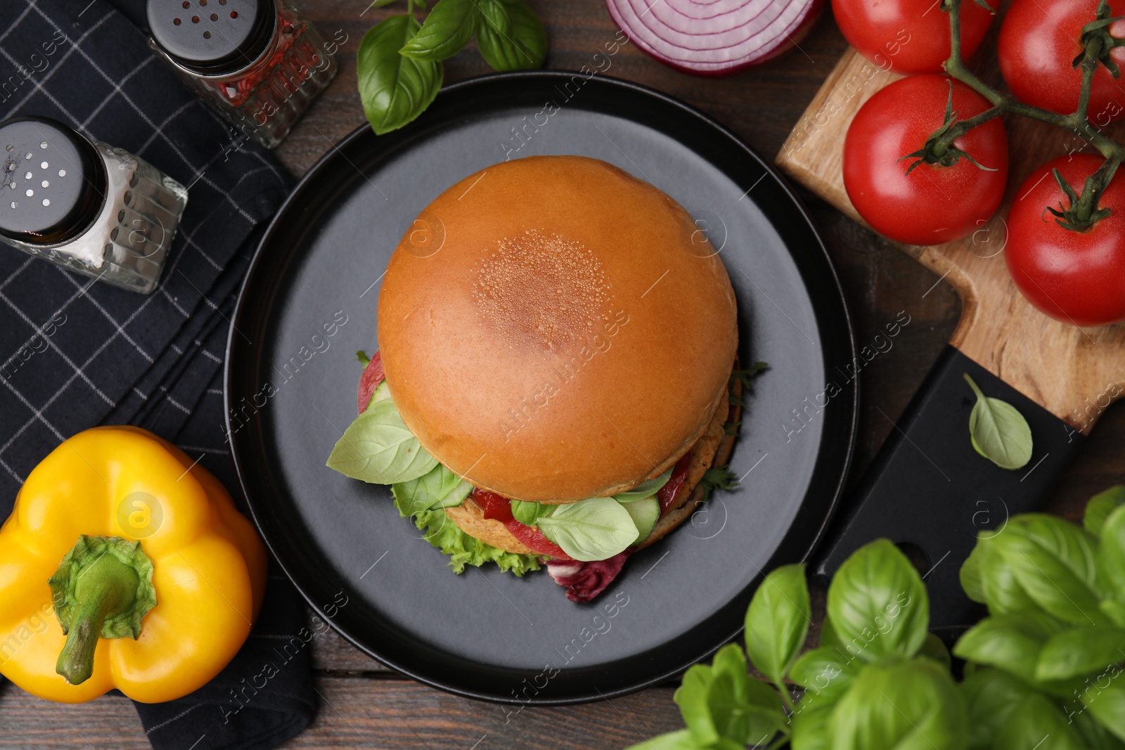 Photo of Delicious vegan burger with chickpea cutlet on wooden table, flat lay